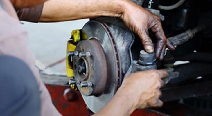 Mechanic Repairing Brakes and Wheel System